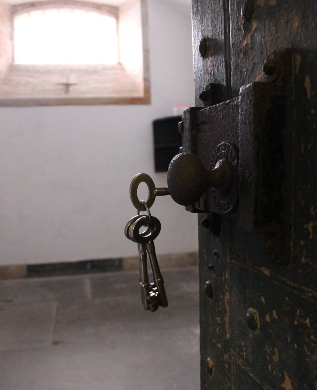 A set of metal keys in a very old looking door at Stirling jail.