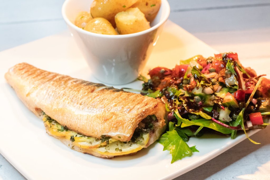 Fish, potatoes and salad are served on a square plate at Brea in Scotland.