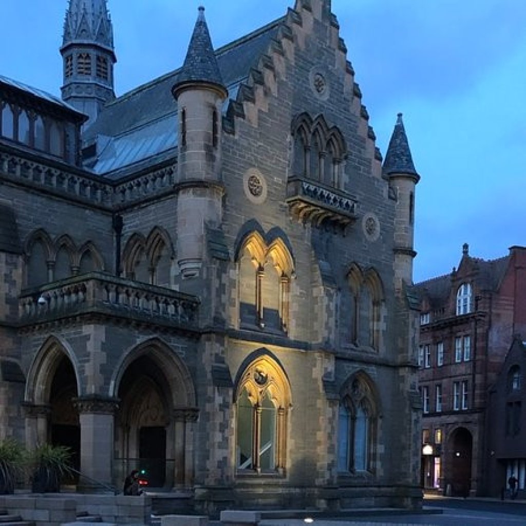 Gothic Revival McManus Art Gallery with pointed arches and turrets against a pale evening sky.