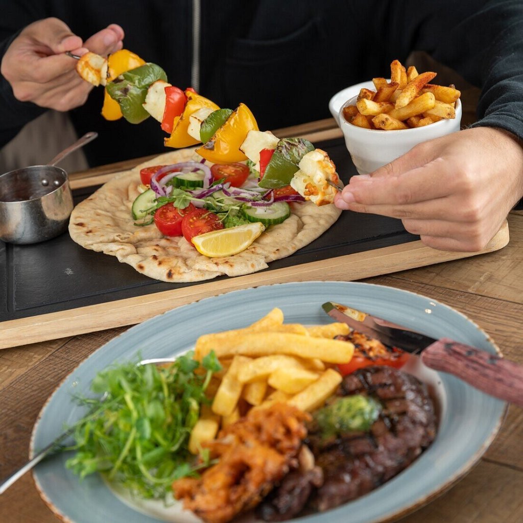 a section of food from the Bell tree pub including steak with chips and a halloumi vegetarian kebab.